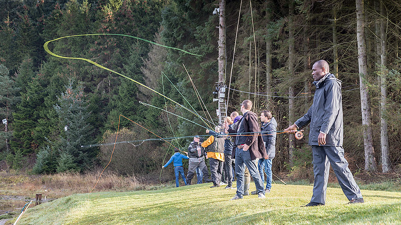 Several people taking fly casting lesson