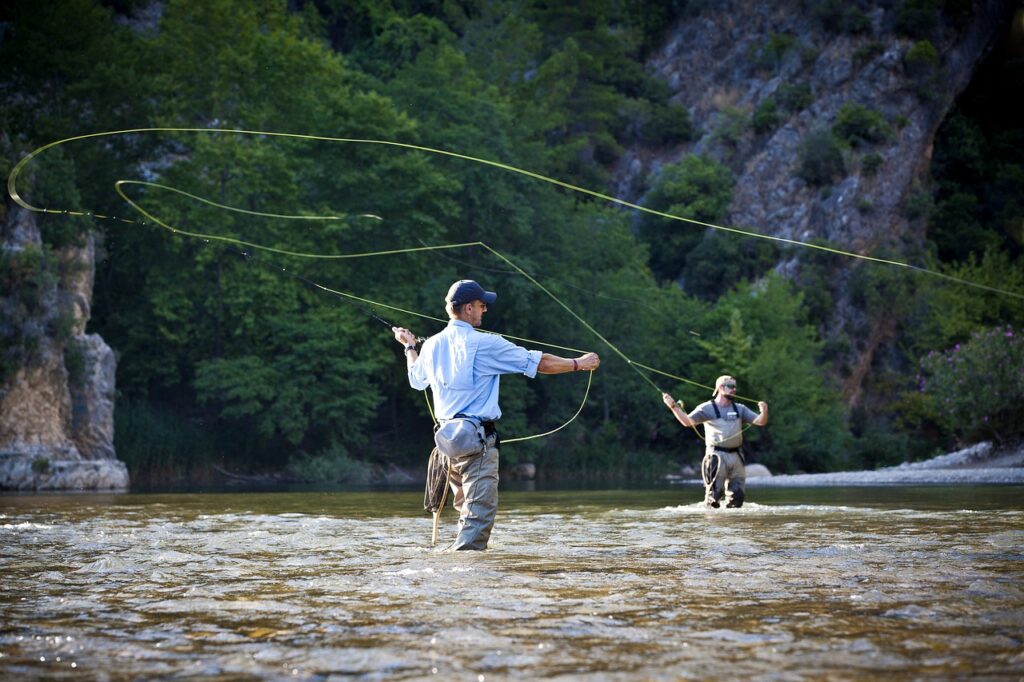 two men fly casting wading in a river