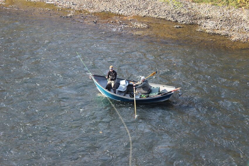 Fly fishing guide with client in drift boat